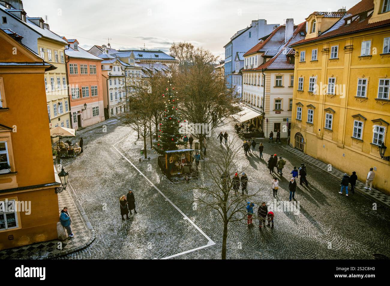 Bezaubernde Winterszene in Malá Strana, Prag mit farbenfrohen Gebäuden und Weihnachtsdekoration Stockfoto