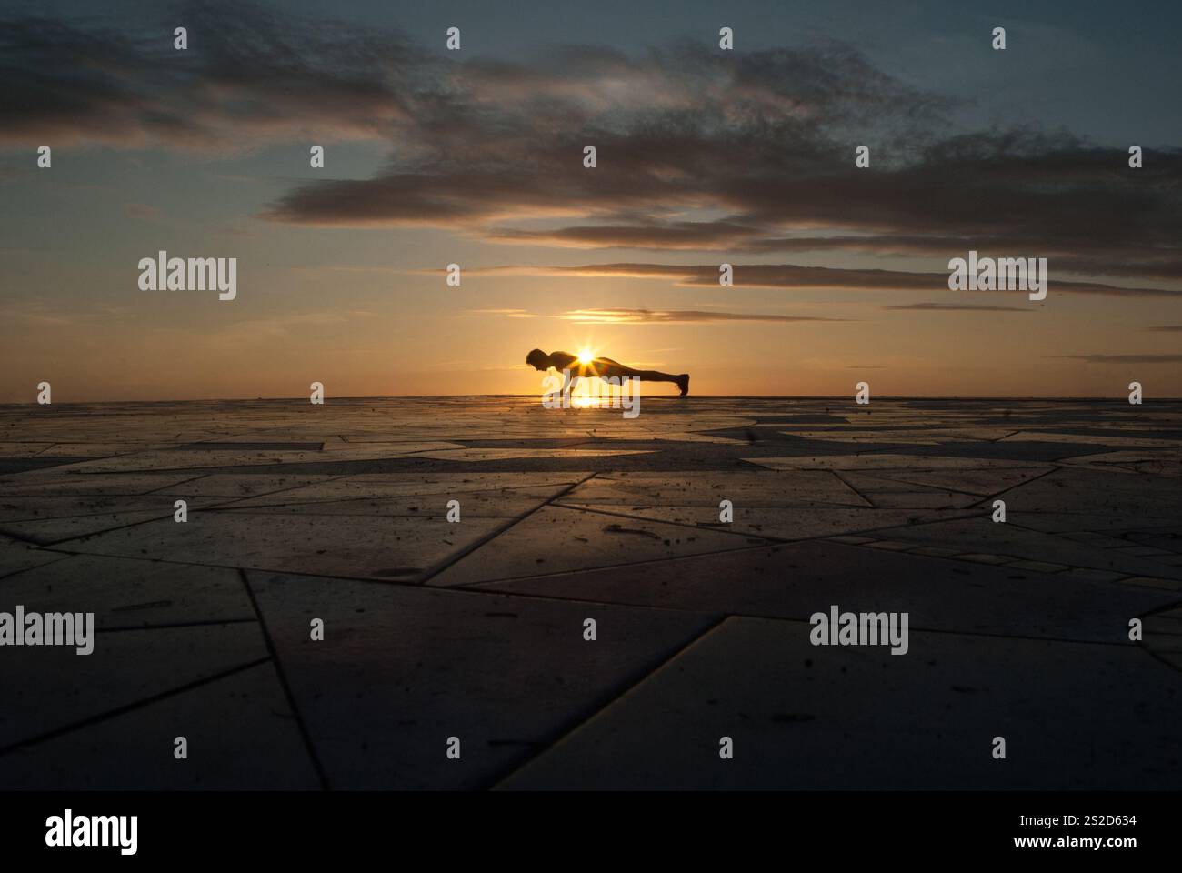 Silhouette eines Mannes, der bei Sonnenuntergang an einem Strand Pressen macht, Spanien Stockfoto