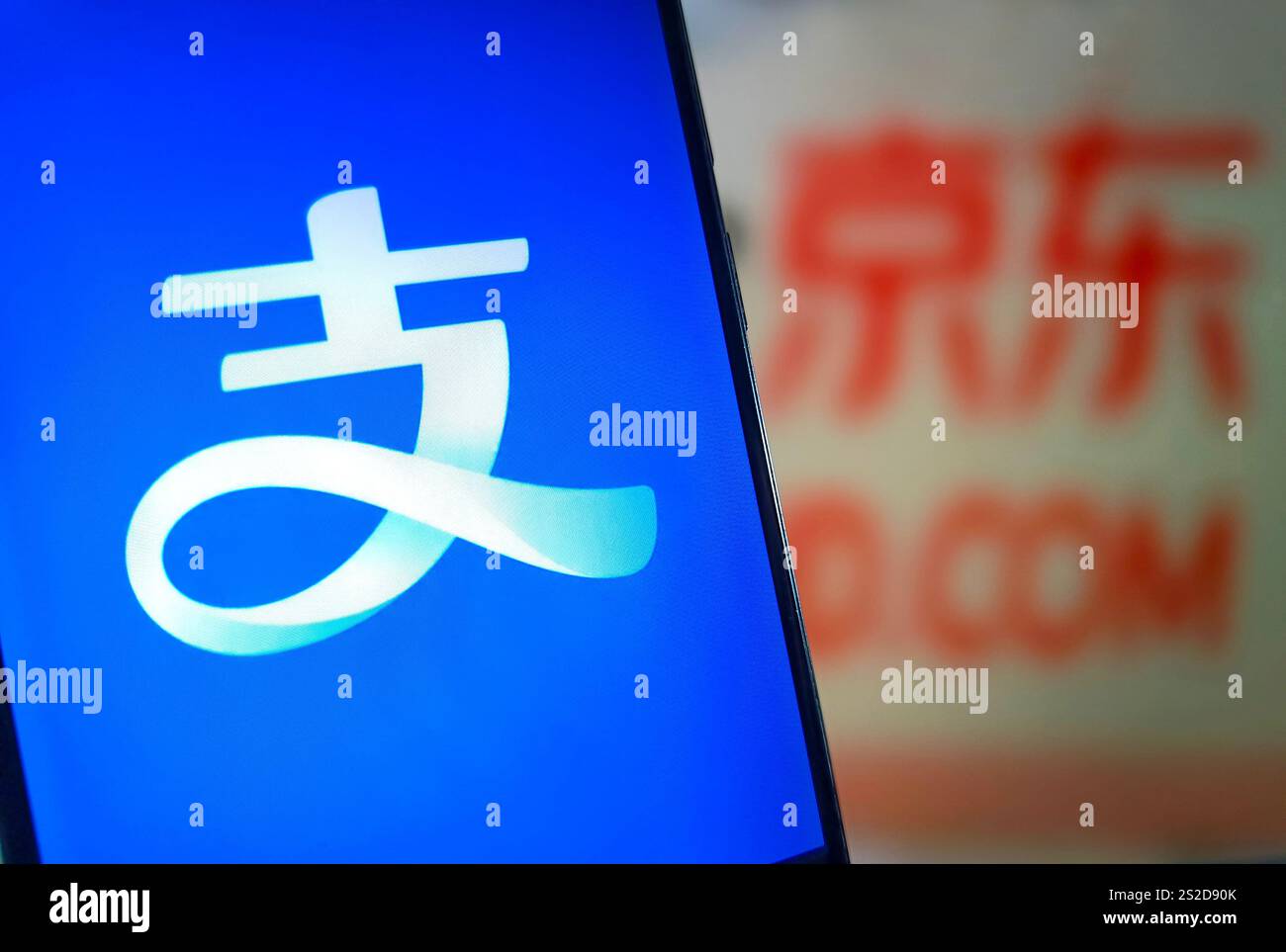 SUQIAN, CHINA - 7. JANUAR 2025 - eine Illustration zeigt Alipay auf einem Mobiltelefon im Hintergrund von JD.com's Seite, Suqian, Provinz Jiangsu, China, Stockfoto