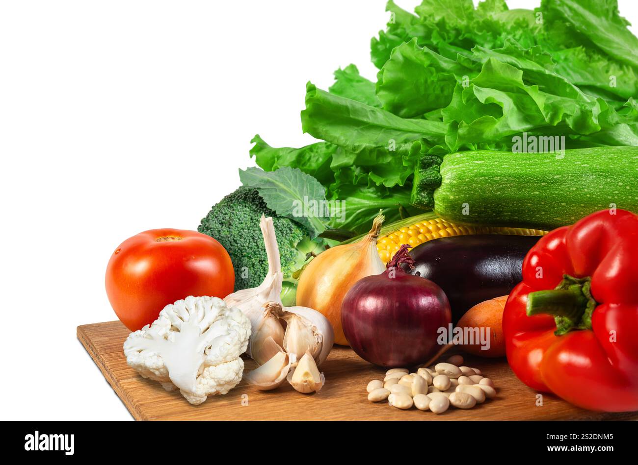 Helles Gemüse, einschließlich Salat, Tomaten, Zucchini und Knoblauch, wird zur Zubereitung der Mahlzeiten ordentlich auf einer hölzernen Oberfläche angeordnet. Stockfoto