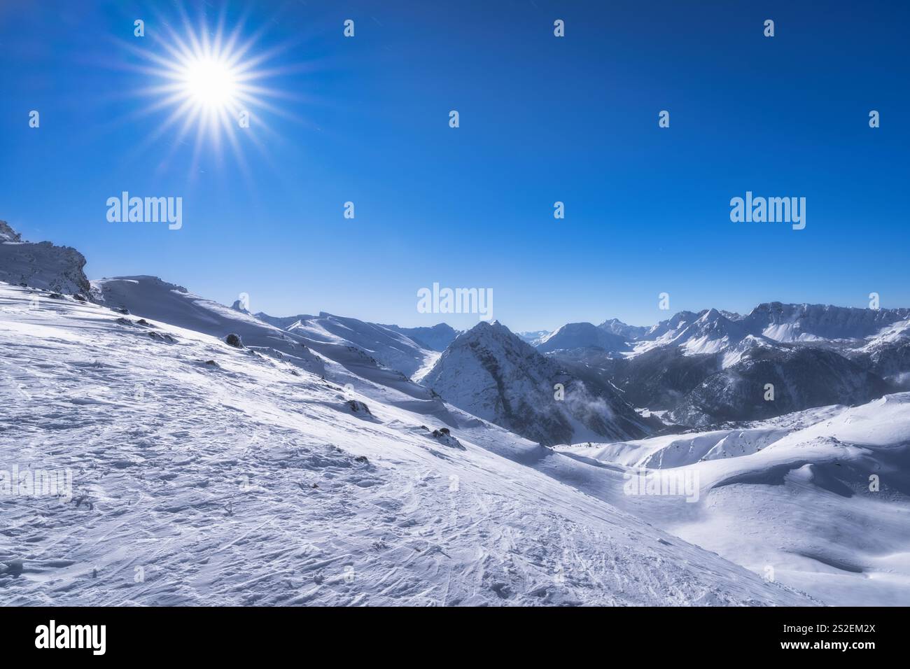 Ein absolut atemberaubender Blick auf die unberührten schneebedeckten Berge, die unter einem perfekt klaren blauen Himmel glitzern, mit einer strahlenden Sonne, die hell scheint Stockfoto