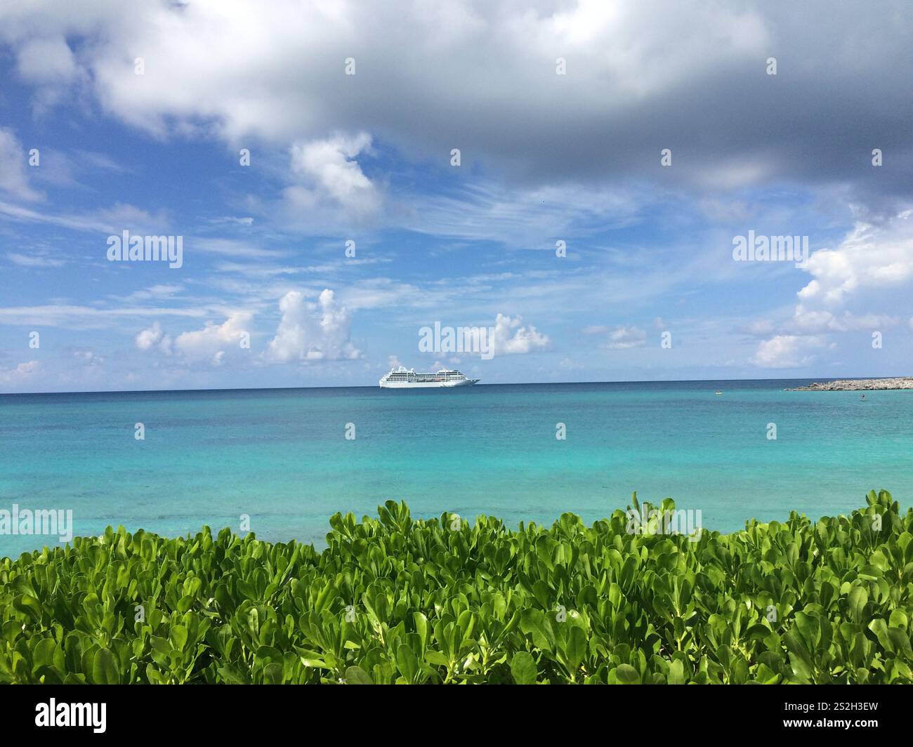 Ruhiges Schiff und türkisfarbenes Wasser unter einem pulsierenden kubanischen Himmel Stockfoto