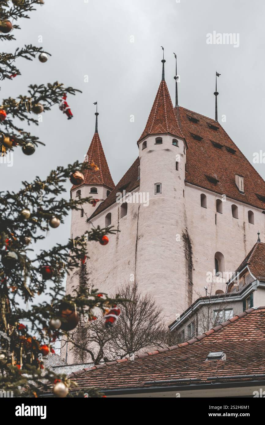 Das Schloss Thun ist eine mittelalterliche Burg in Thun. Eine Stadt im Kanton Bern - Schweiz. Bewölkter Wintertag, Weihnachtsbaum im Vordergrund Stockfoto