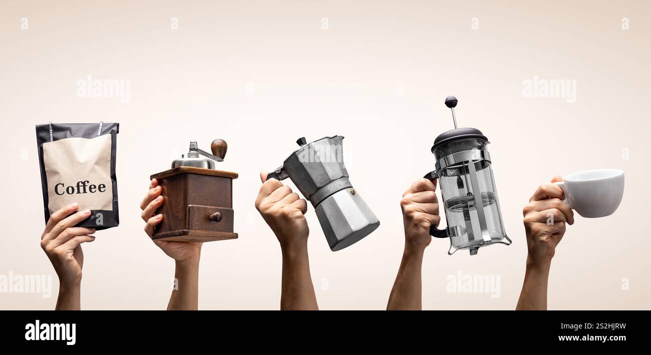 Hände halten Kaffeegeräte hoch Stockfoto