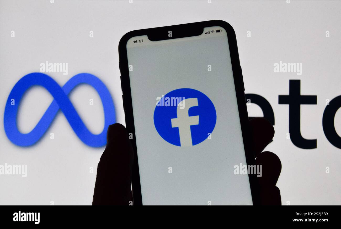 In dieser Fotoabbildung wird das Facebook-Logo auf einem Smartphone und das Meta-Logo im Hintergrund angezeigt. Meta-Gründer Mark Zuckerberg hat angekündigt, dass der Social-Media-Riese die Zensur reduzieren, mehr politische Inhalte empfehlen und Faktenüberprüfungen entfernen wird und sie durch „Community Notes like like like X“ auf Facebook ersetzen wird. Stockfoto
