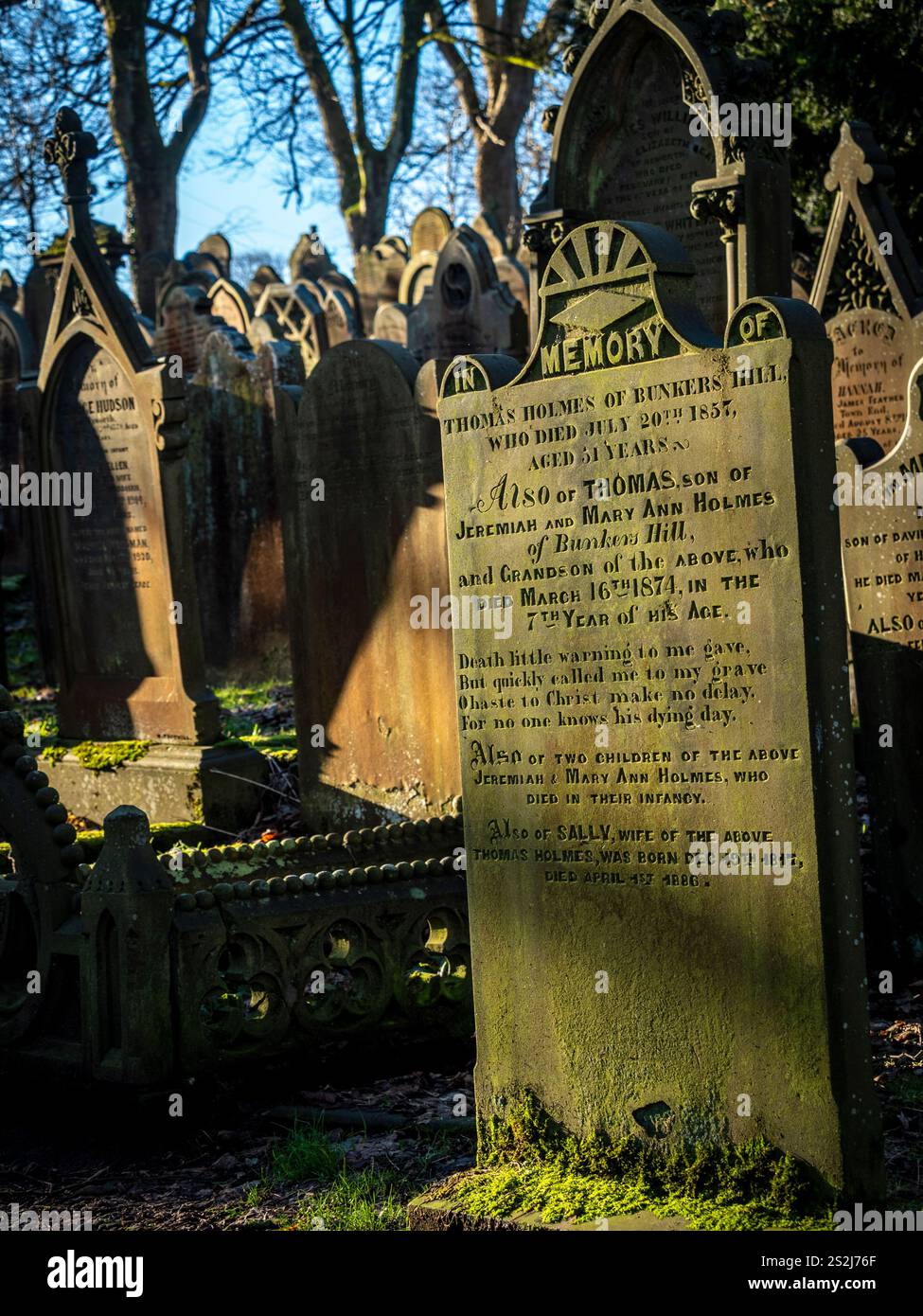 Grabsteine auf dem sonnendurchfluteten Friedhof der St. Michael All Angels Church in Haworth, Bronte Country, West Yorkshire. UK Stockfoto