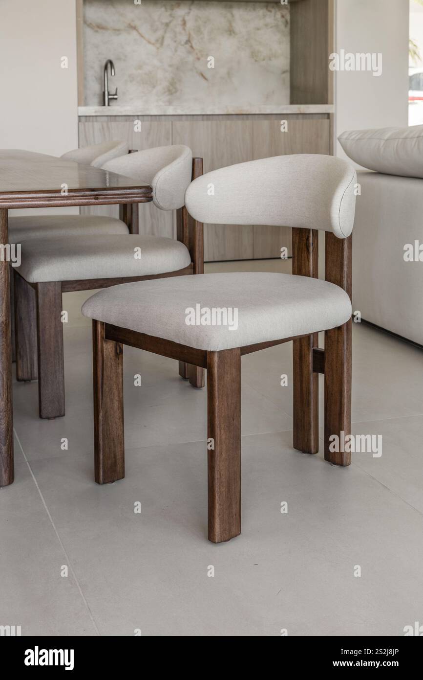 Ein Holzstuhl mit weißer Polsterung, der natürliche Materialien und ein klares, elegantes Design kombiniert. Stockfoto