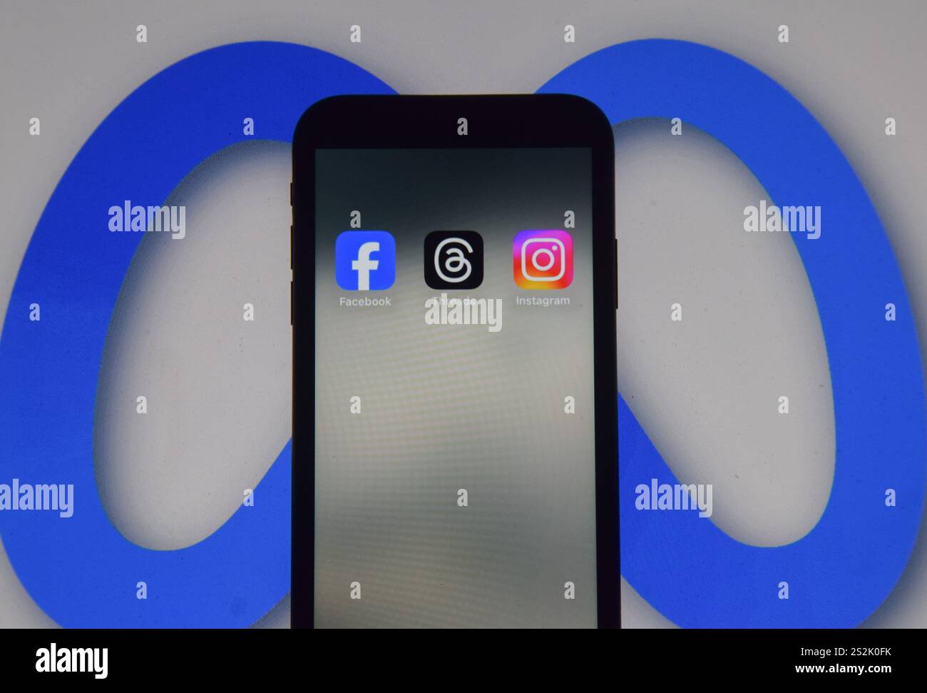 London, Großbritannien. Januar 2025. Facebook-, Threads- und Instagram-Apps auf einem Telefonbildschirm und das Meta-Logo im Hintergrund, als Meta-Gründer Mark Zuckerberg ankündigt, dass der Social-Media-Gigant die Zensur reduzieren wird, mehr politische Inhalte empfehlen und Faktenüberprüfungen in seinen Apps entfernen wird und sie durch „Community Notes like like X“ ersetzt. Quelle: Vuk Valcic/Alamy Stockfoto