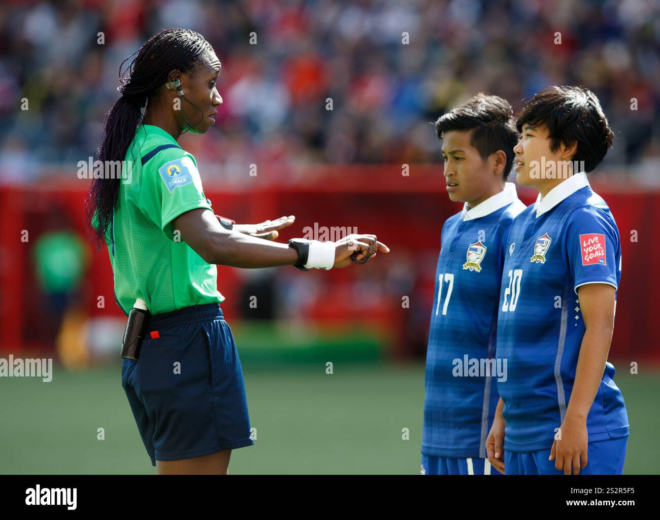 WINNIPEG, KANADA - 15. JUNI: Schiedsrichter Gladys Lengwe warnt die thailändischen Spieler Anootsara Maijarern (17) und Wilaiporn Boothduang (20) während eines Spiels der FIFA Frauen-Weltmeisterschaft Gruppe B gegen Deutschland am 15. Juni 2015 im Winnipeg-Stadion in Winnipeg, Kanada. Nur redaktionelle Verwendung. Kommerzielle Nutzung verboten. (Foto: Jonathan Paul Larsen / Diadem Images) Stockfoto
