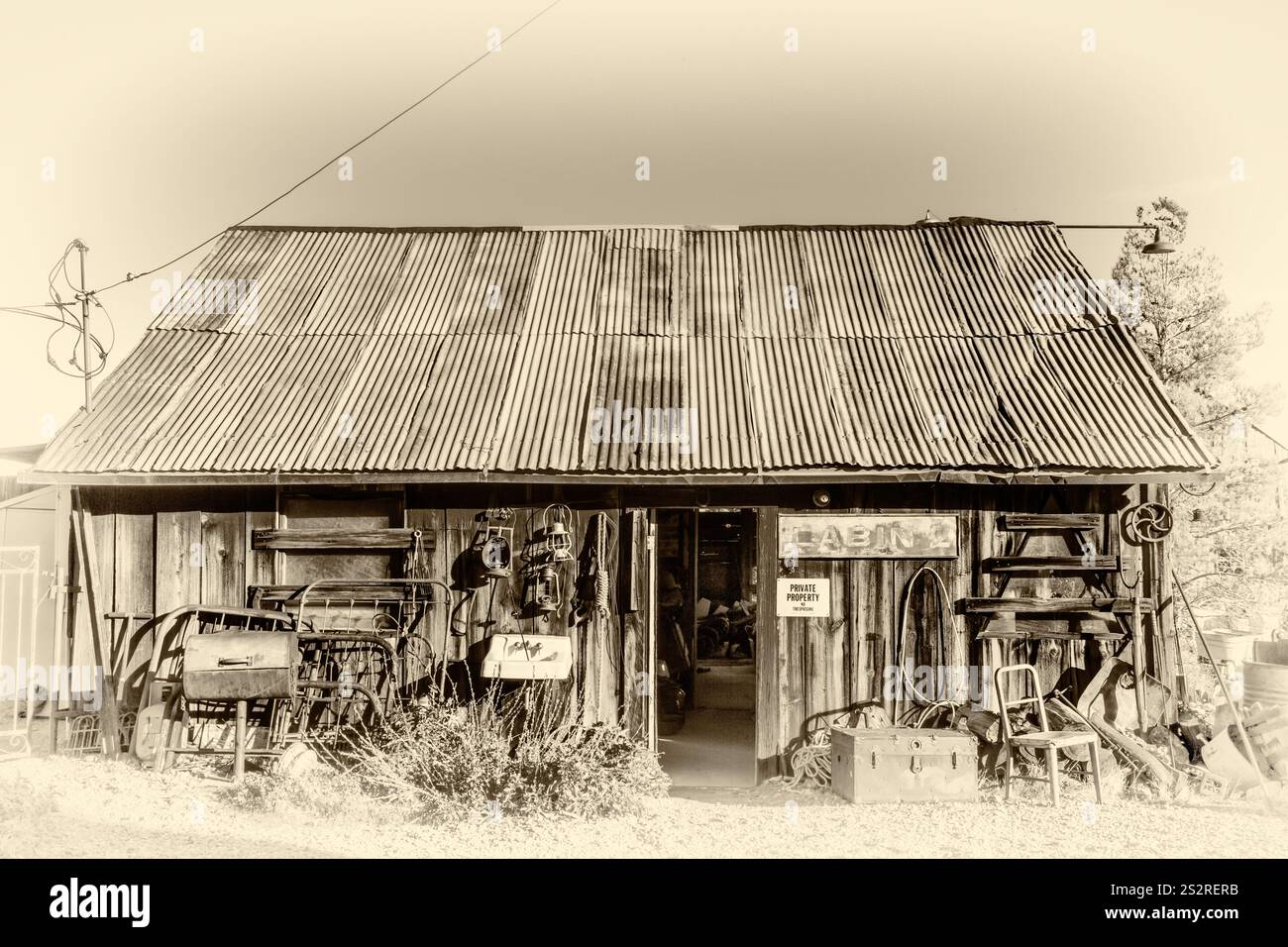 Eine rustikale Scheune mit einem Schild, auf dem "Tankstelle" steht. Die Scheune ist mit alten Maschinen und Werkzeugen gefüllt, was ihr ein Vintage-und nostalgisches Flair verleiht Stockfoto