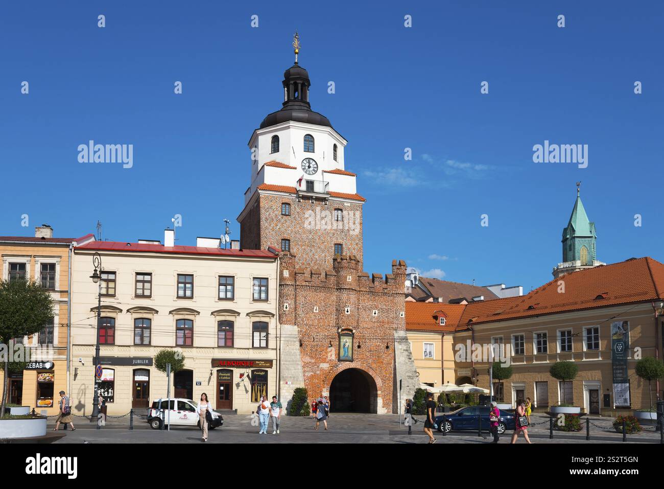 Historisches Stadttor mit Backsteinturm und Türmchen vor einem belebten Platz mit Passanten, Krakauer Tor, Brama Krakowska, Lokietka Platz, Lublin, P Stockfoto