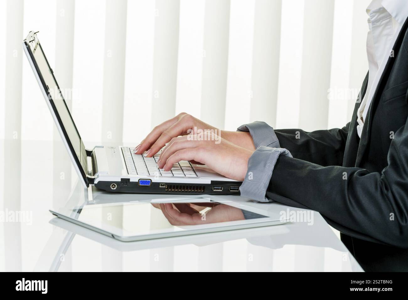 Eine Frau arbeitet in einem Büro mit einem Laptop in Österreich Stockfoto