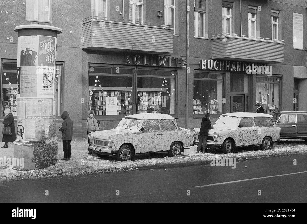 02.11.1983, DDR, Ost-Berlin, Bezirk Prenzlauer Berg, Dimitroffstraße, Kinder spielen mit Schnee am Straßenrand vor dem Kollwitz-Buchladen Stockfoto