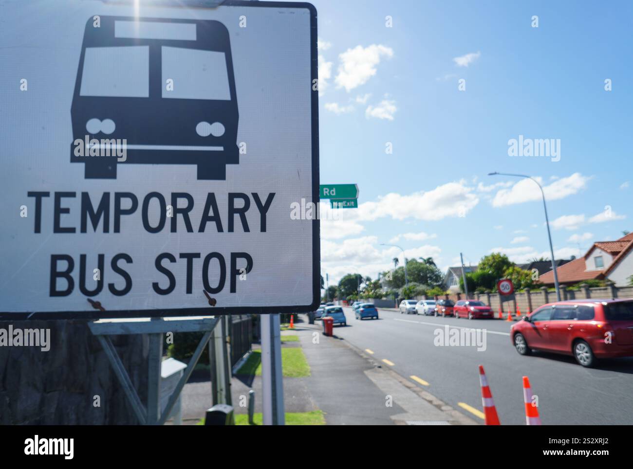 Schild für temporäre Bushaltestelle an der Straße. Autos, die auf der Straße unterwegs sind. Bauarbeiten in Auckland. Stockfoto