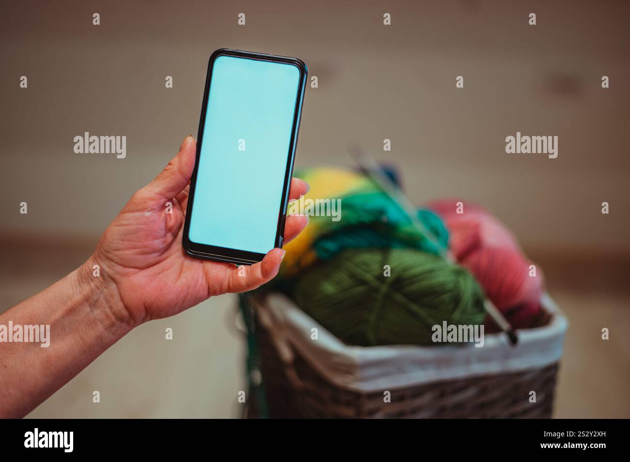 Nahaufnahme einer zerknitterten Hand einer älteren Frau, die einen Smartphone-Bildschirm hält. Modell-Konzept. Leerzeichen für Text. Alter und Technik. Stockfoto