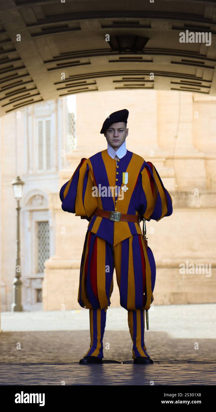Die Päpstliche Schweizergarde. Eine gutaussehende Wache im Vatikan mit einer Stirnrunze und seiner farbenfrohen und charakteristischen Uniform. Rom, Vatikan, Italien. Stockfoto Die Päpstliche Schweizergarde. Eine gutaussehende Wache im Vatikan mit einer Stirnrunze und seiner farbenfrohen und charakteristischen Uniform. Rom, Vatikan, Italien. Stockfoto