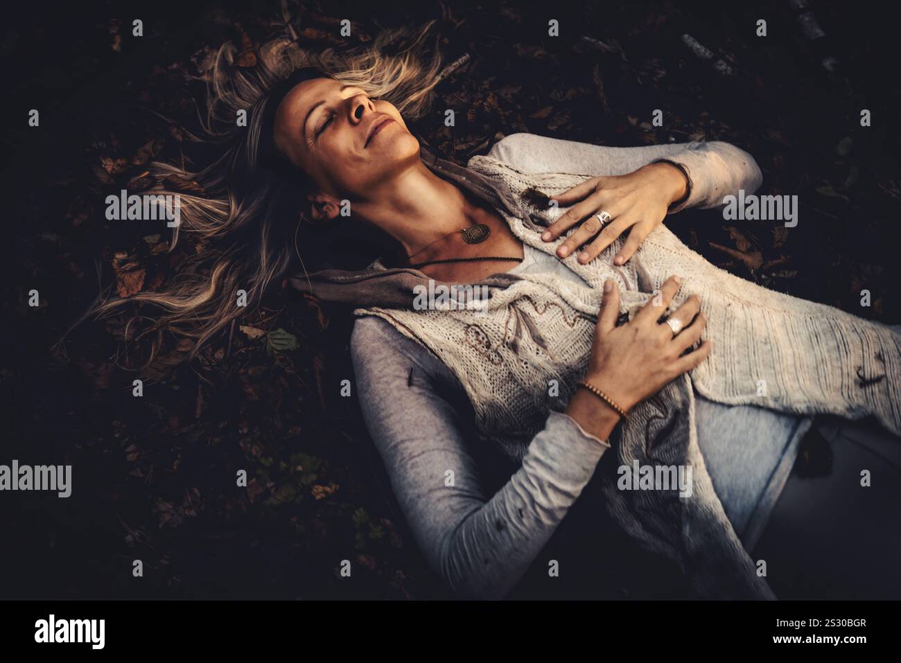 Eine Frau, die freudig die Schönheit der Natur umgibt, umgeben von Herbstlaub Stockfoto