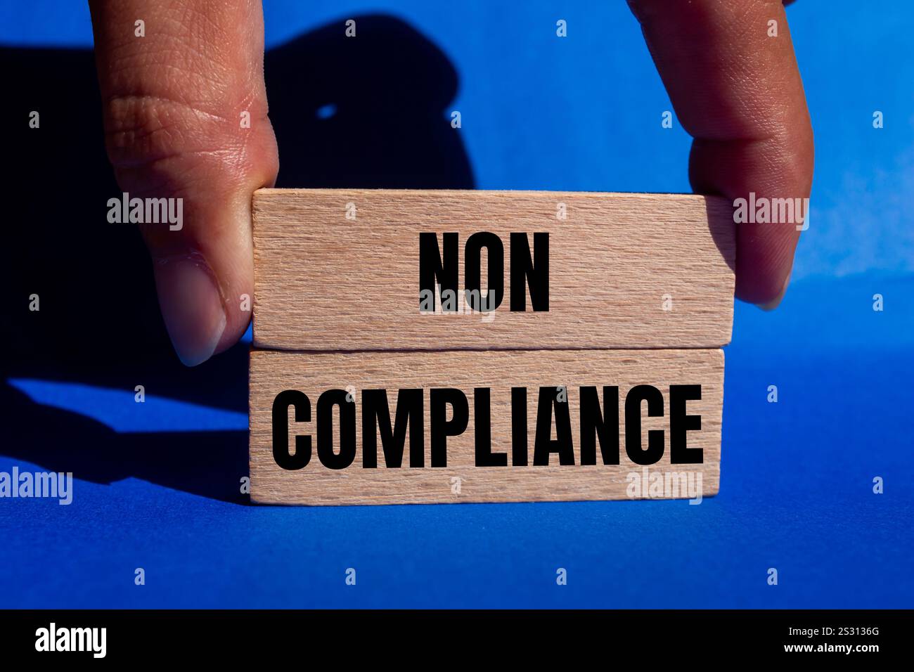 Meldung über Nichteinhaltung auf Holzblöcken mit blauem Hintergrund. Symbol für konzeptionelle Nichteinhaltung. Kopierbereich. Stockfoto