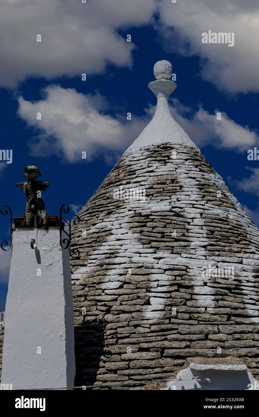 Das Dach eines restaurierten trullo in Alberobello, Apulien, Italien, das ohne Mörtel oder Zement gebaut wurde, trägt ein weiß gemaltes christliches Symbol, das mit dem Psalm Davids in der King James Version (KJV) der Bibel von 1611 verbunden ist. Stockfoto
