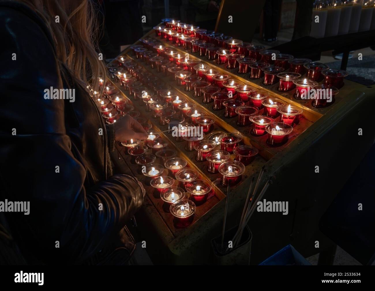 Frau zündet Votivkerzen in der Basilika Sacre Coeur, Montmartre, Paris, Frankreich an Stockfoto