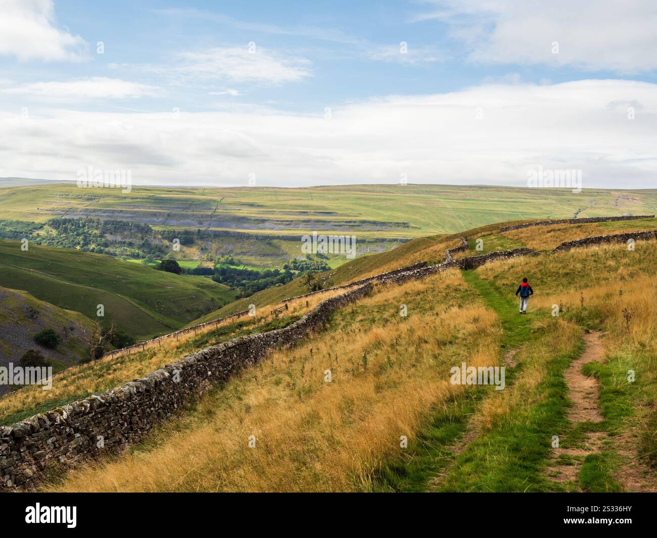 Ein Junge läuft in den Yorkshire Dales. Er ist unfreundlich, draußen zu sein und die Aussicht zu genießen Stockfoto