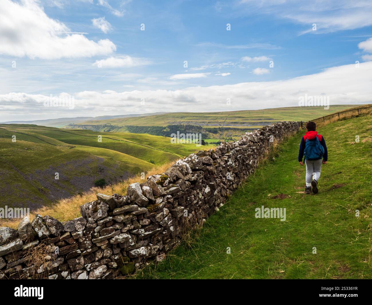 Ein Junge läuft in den Yorkshire Dales. Er ist unfreundlich, draußen zu sein und die Aussicht zu genießen Stockfoto