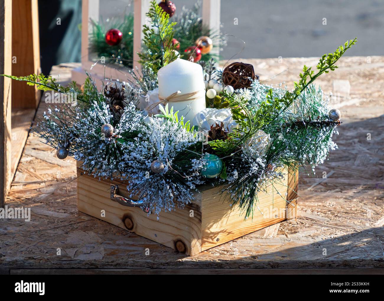 Holzkiste mit dekorativen Weihnachtszweigen aus Kiefernholz und Kerze im Inneren Stockfoto