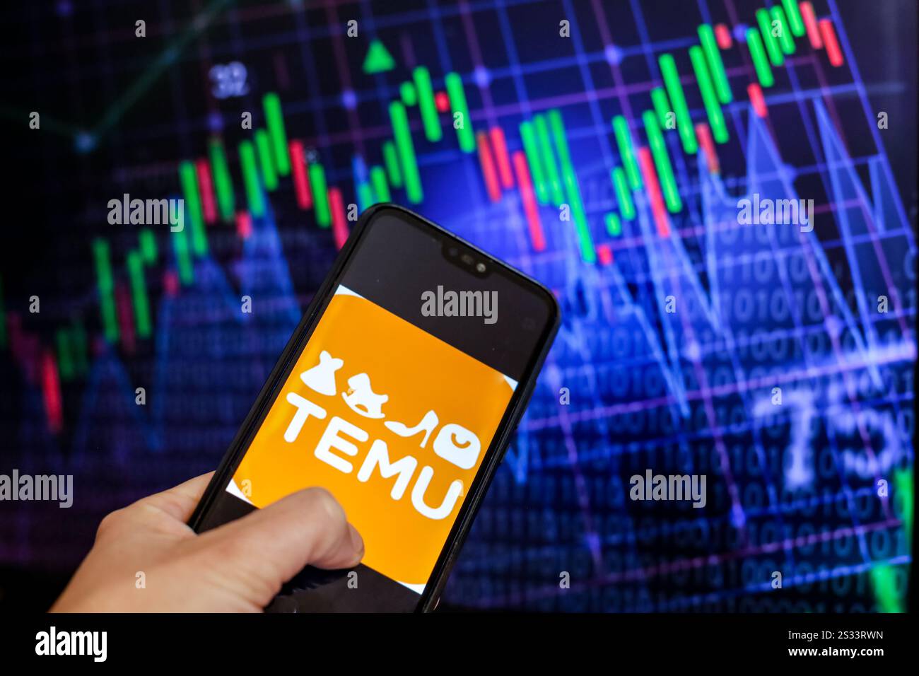 In dieser Fotoabbildung wird das Temu-Logo, eine Online-Plattform für eCommerce, auf einem Smartphone-Bildschirm vor einem Computerbildschirm mit einem Bild angezeigt Stockfoto