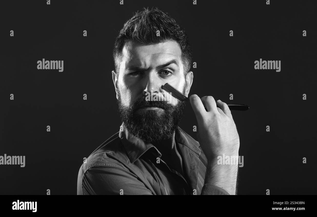 Friseurwerbung. Friseurausrüstung. Gutaussehender Mann mit Bart und Schnurrbart hält Rasierer. Professionelle Bartpflege. Friseurwerkzeug. Bärtige Male Stockfoto