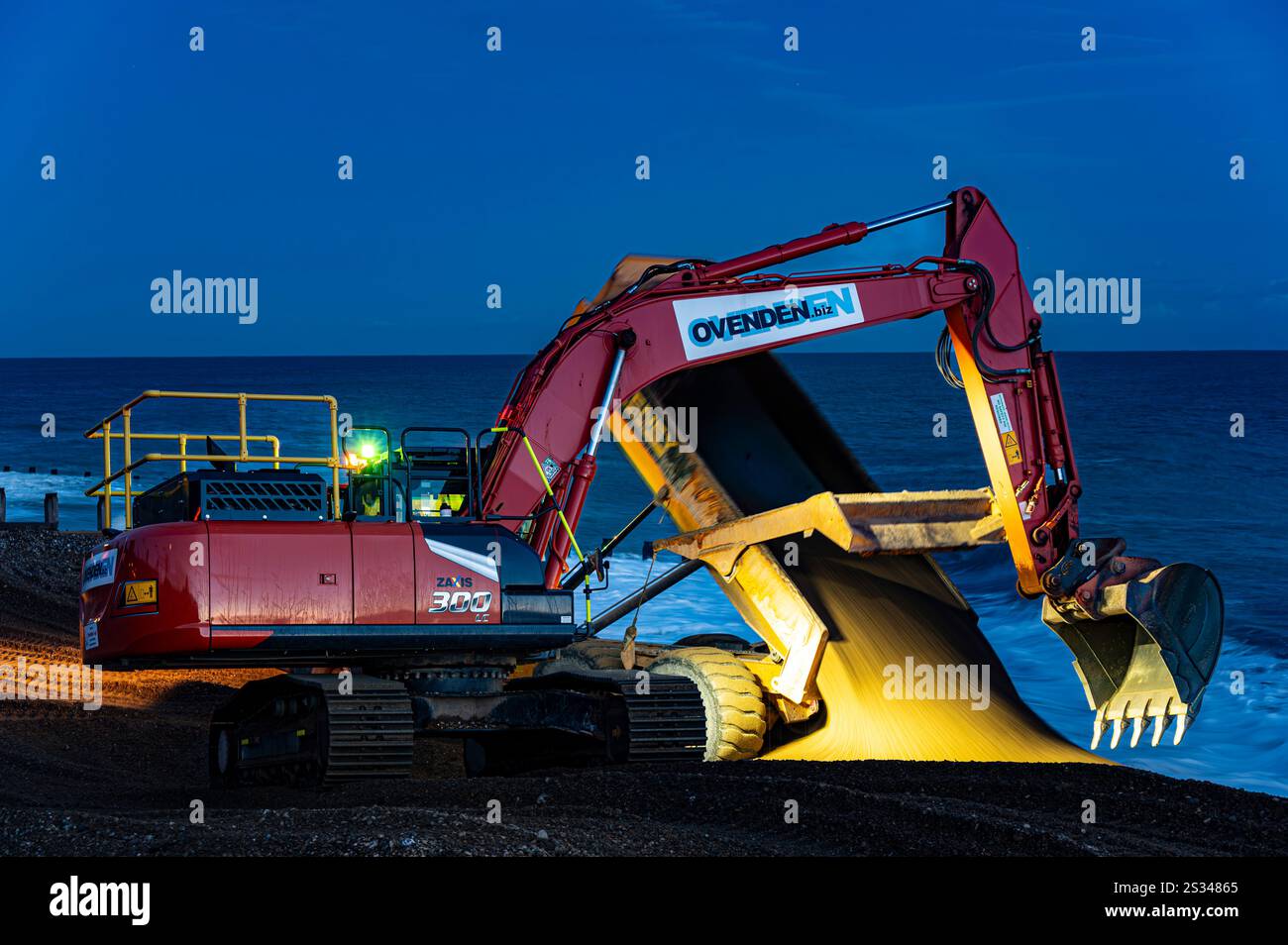 Die Auftragnehmer der Umweltbehörde arbeiten, spät in den winterlichen kurzen Tag, für das Pevensey Bay to Eastbourne Coastal Management Scheme Stockfoto