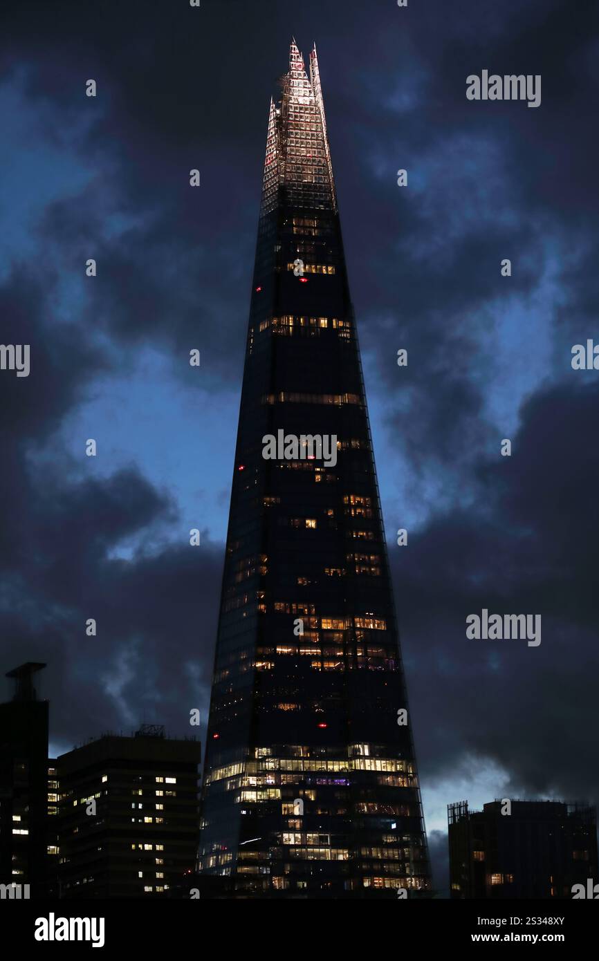 Der Shard mit seinem beleuchteten Turm erhebt sich nachts aus der Stadt London. Es ist das höchste Gebäude in Großbritannien und bietet Büros, Restaurants und Klimaanlage Stockfoto