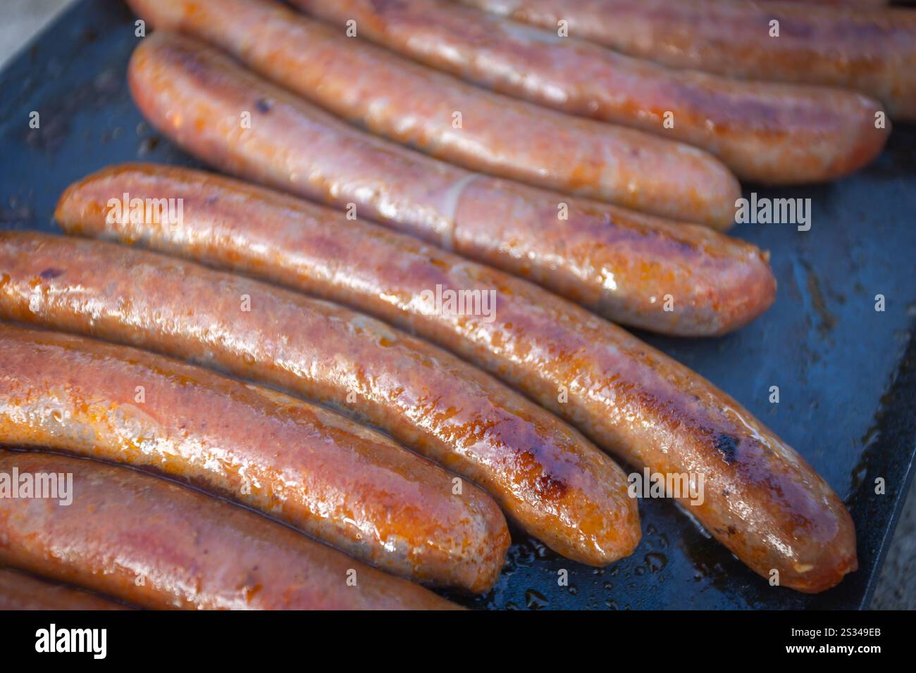 Mehrere Merguez-Würstchen kochen auf einem Grill, Nahaufnahme. Stockfoto