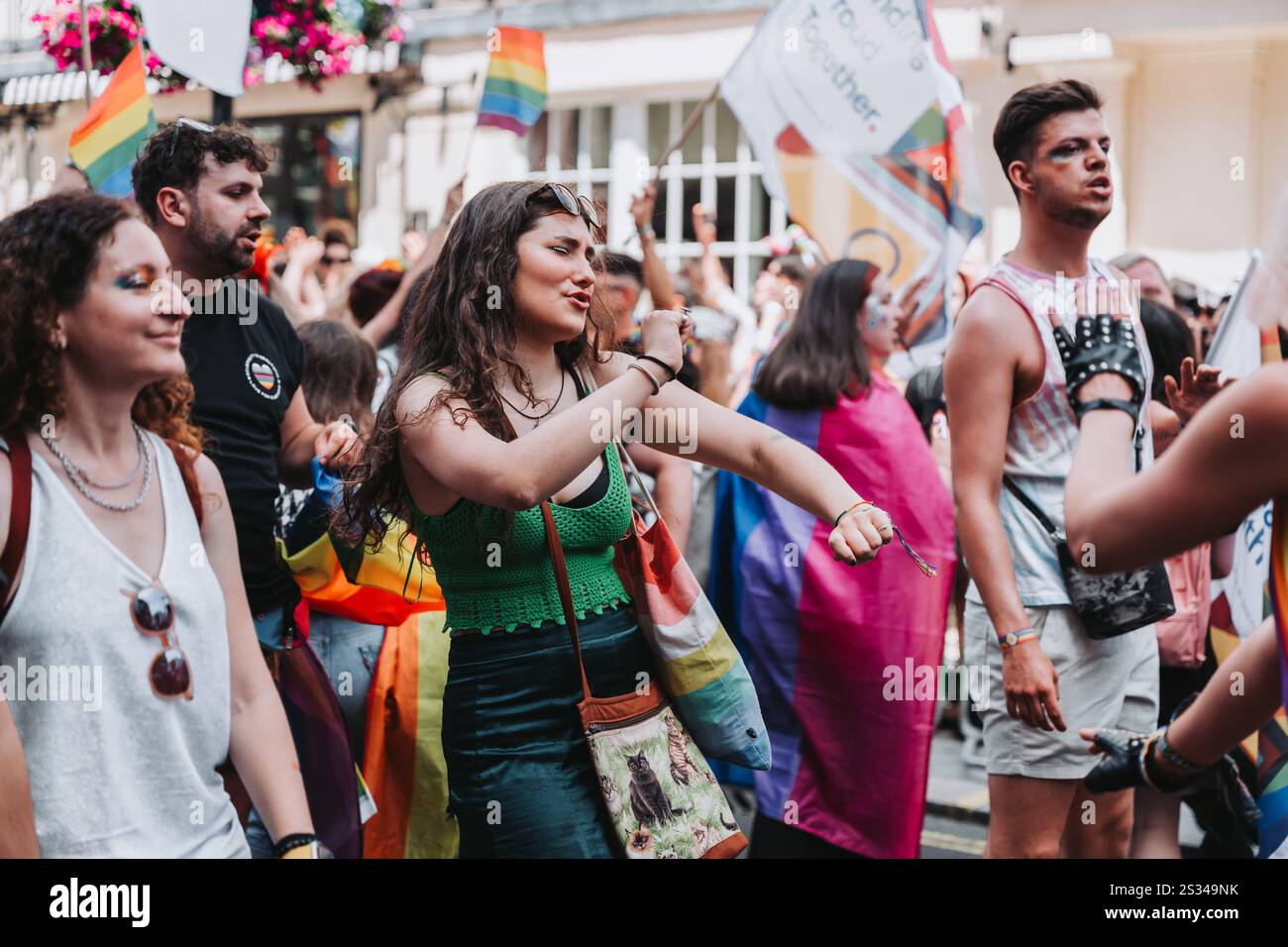 Vibrierende Feier bei LGBTQ+ Pride Parade mit Tanz- und Regenbogenflaggen Stockfoto