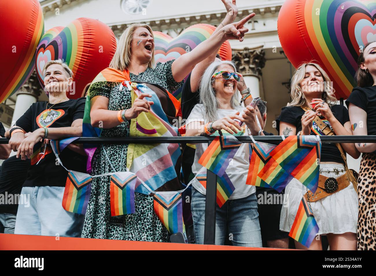 Farbenfrohe öffentliche Versammlung, bei der verschiedene Einzelpersonen bei einer LGBTQ+ PRIDE-Veranstaltung Einheit und Gleichheit feiern. London 2024 Stockfoto