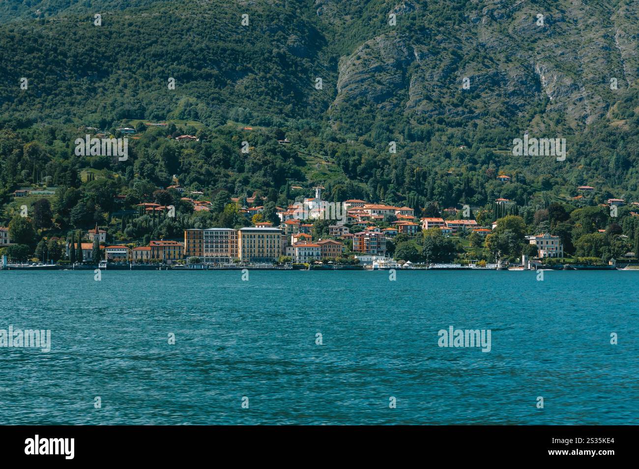 Der Comer See spiegelt die farbenfrohen Häuser von Bellagio wider, einem charmanten Dorf zwischen grünen Bergen in der Lombardei, Italien Stockfoto