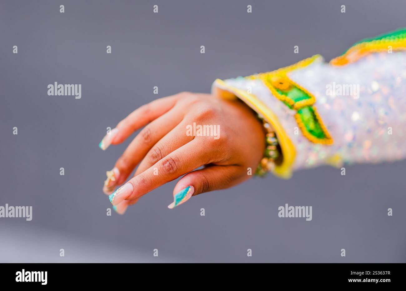 Nahaufnahme der Hand eines Tänzers mit verzierten Nägeln und traditioneller Kleidung während einer hispanic Day Parade Stockfoto
