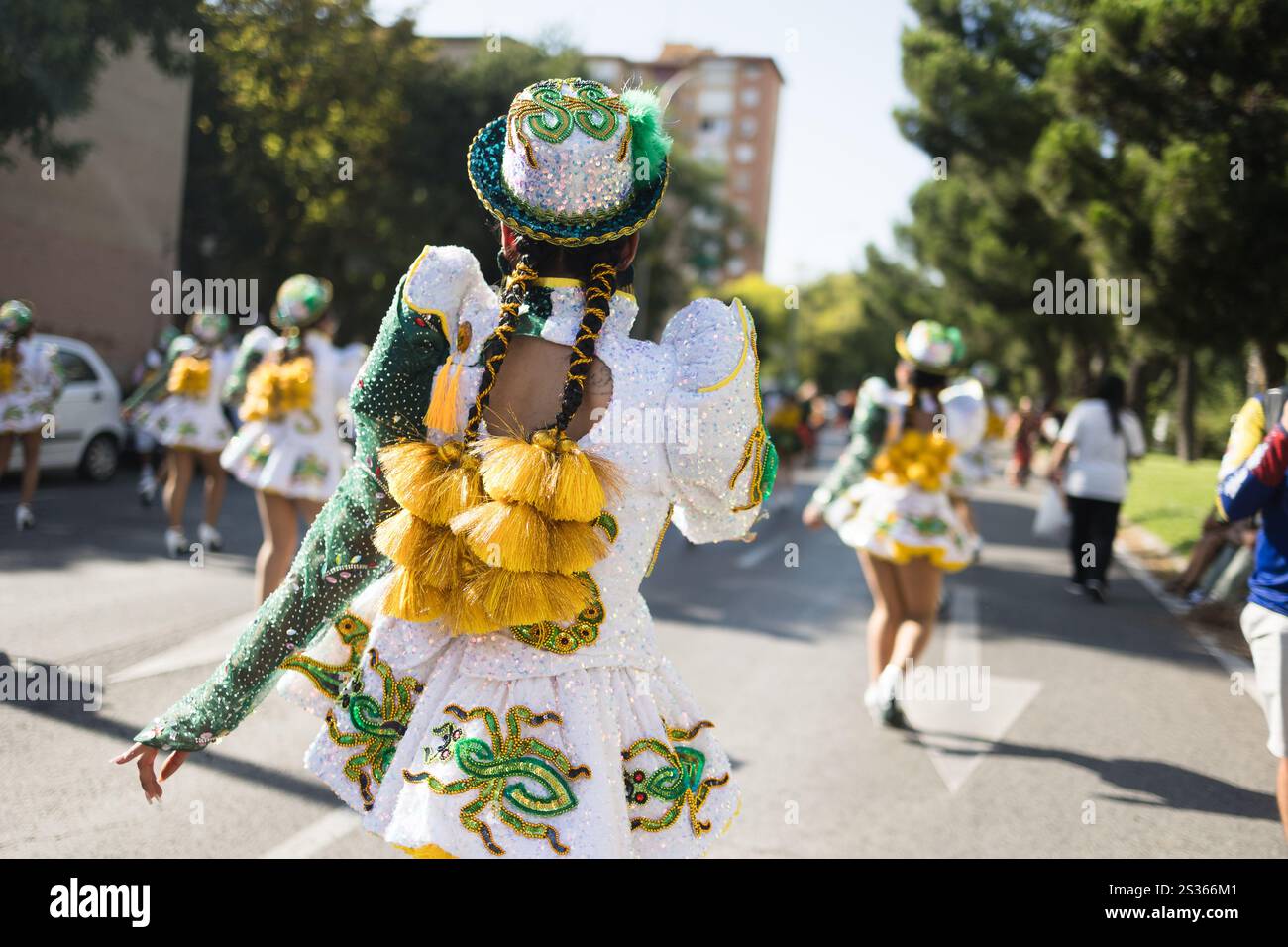 Frau in farbenfrohen Volkstrachten tanzt bei einer Straßenparade, die Dia de la hispanidad feiert, auch bekannt als kolumbus-Tag oder Nationalfeiertag spaniens Stockfoto