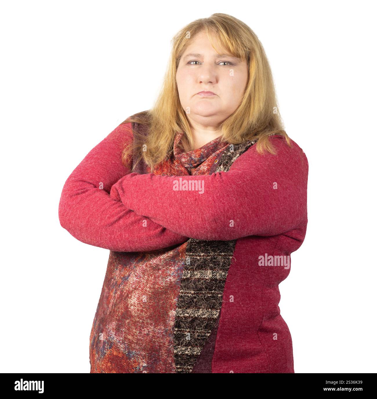 Eine Frau mit langen blonden Haaren, die einen rot gemusterten Pullover trägt, steht mit gefalteten Armen. Stockfoto Eine Frau mit langen blonden Haaren, die einen rot gemusterten Pullover trägt, steht mit gefalteten Armen. Stockfoto