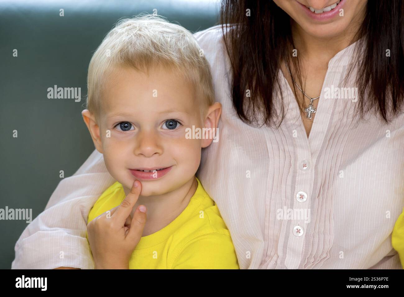 Ein kleiner Junge lehnt sich nachdenklich auf die Schulter seiner Mutter Österreich Stockfoto