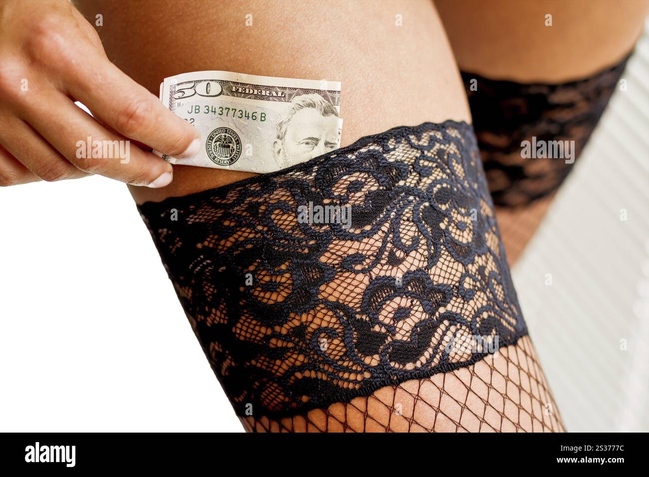 Eine junge Frau stirbt eine Dollarnote in ihrem Strumpf. Symbolfoto für Prostitution Österreich Stockfoto