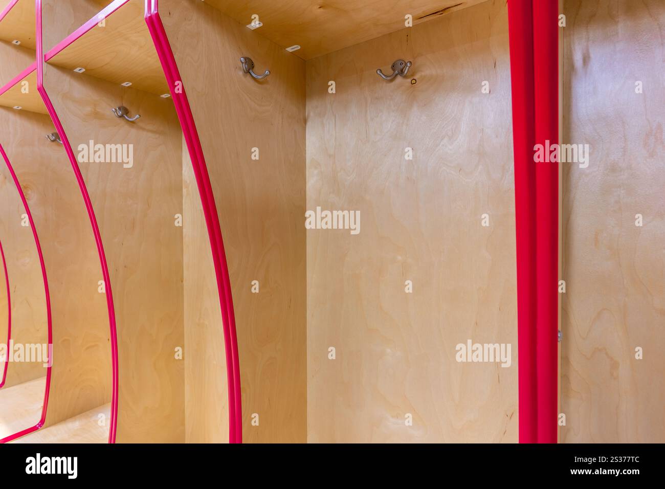 Nahaufnahme eines leeren Schließfachs des Teams, Umkleideraum mit traditionellen offenen Holzschränken mit roter Zierleiste. Stockfoto