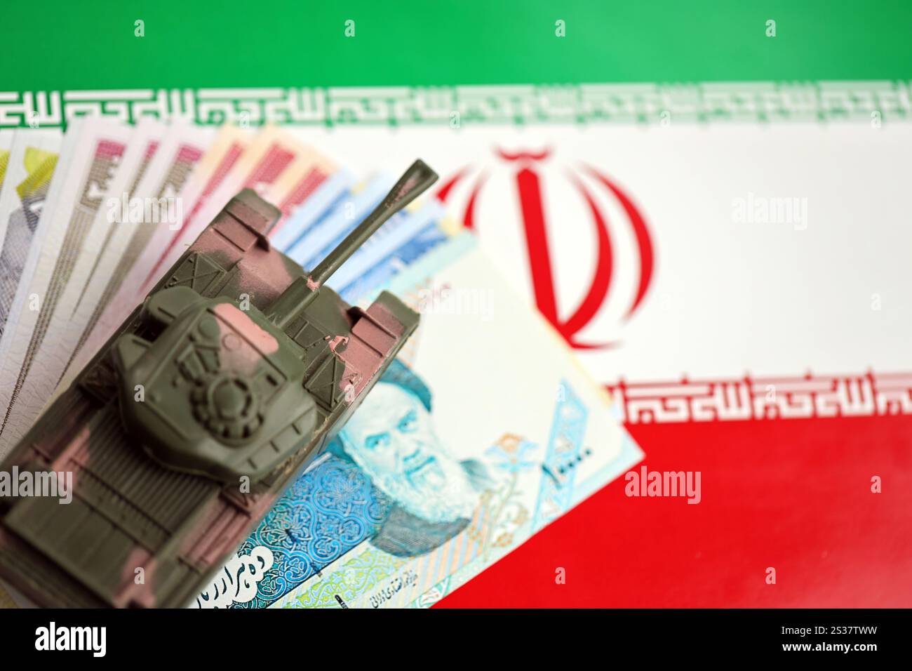 Iranische Armee Spielzeugpanzer-Antrieb auf iranischen Rial-Wechseln auf der Flagge der Islamischen Republik Iran Nahaufnahme. Iranische Armee-Spielzeugpanzer-Antrieb auf iranische Stockfoto