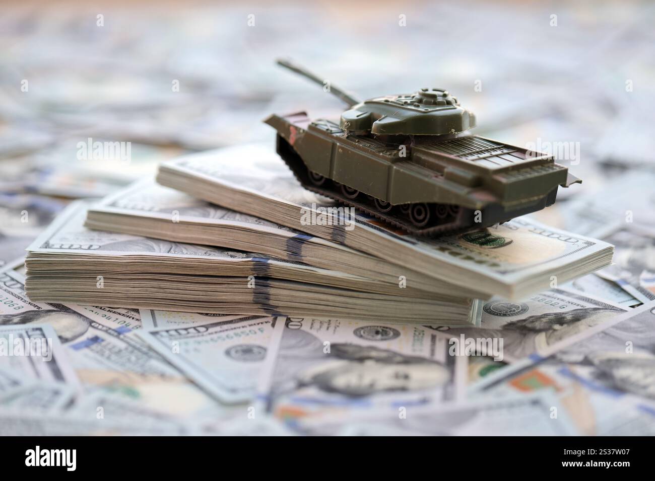 Spielzeugtank auf US-Dollar-Banknoten aus nächster Nähe. Das Konzept der Kriegskosten, der Militärausgaben und der Wirtschaftskrise. Spielzeugtank auf US Hundred Stockfoto