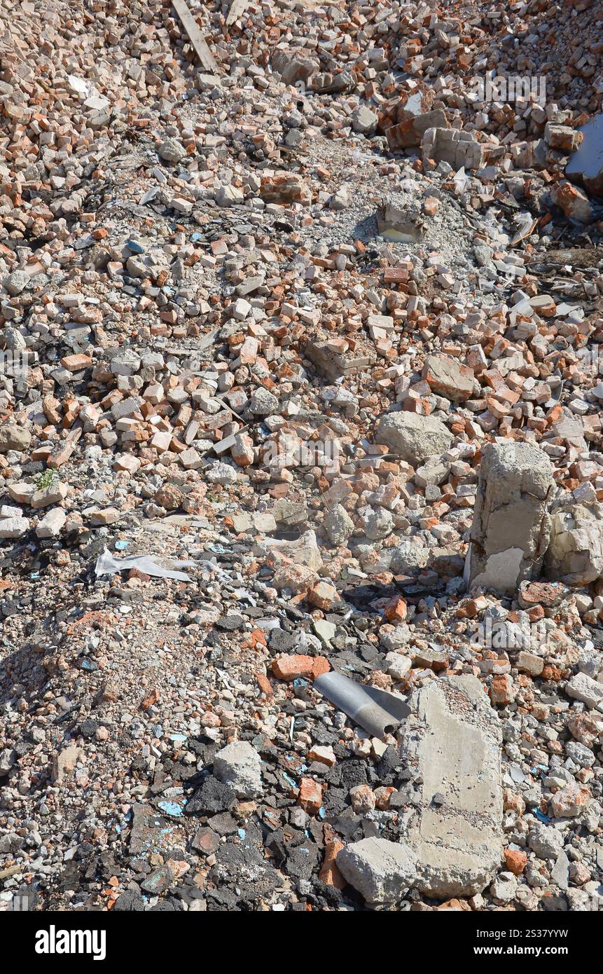 Haufen von gebrochenen roten Ziegeln und Betonfragmenten aus zerstörtem Gebäude. Bruchziegel schließen Abriss oder Zerstörung von Gebäuden. Stockfoto