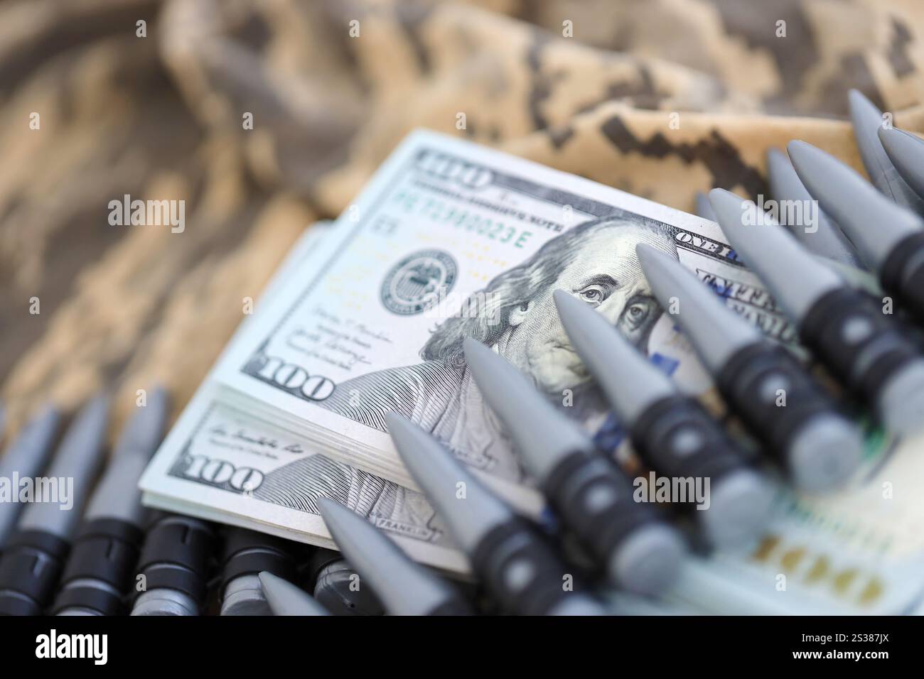 Dollarbündel und ein Maschinengewehrgürtel auf der Tarnuniform eines ukrainischen Soldaten. Konzept der Kriegsfinanzierung, Bestechung oder Spende. Hilfe zu Stockfoto