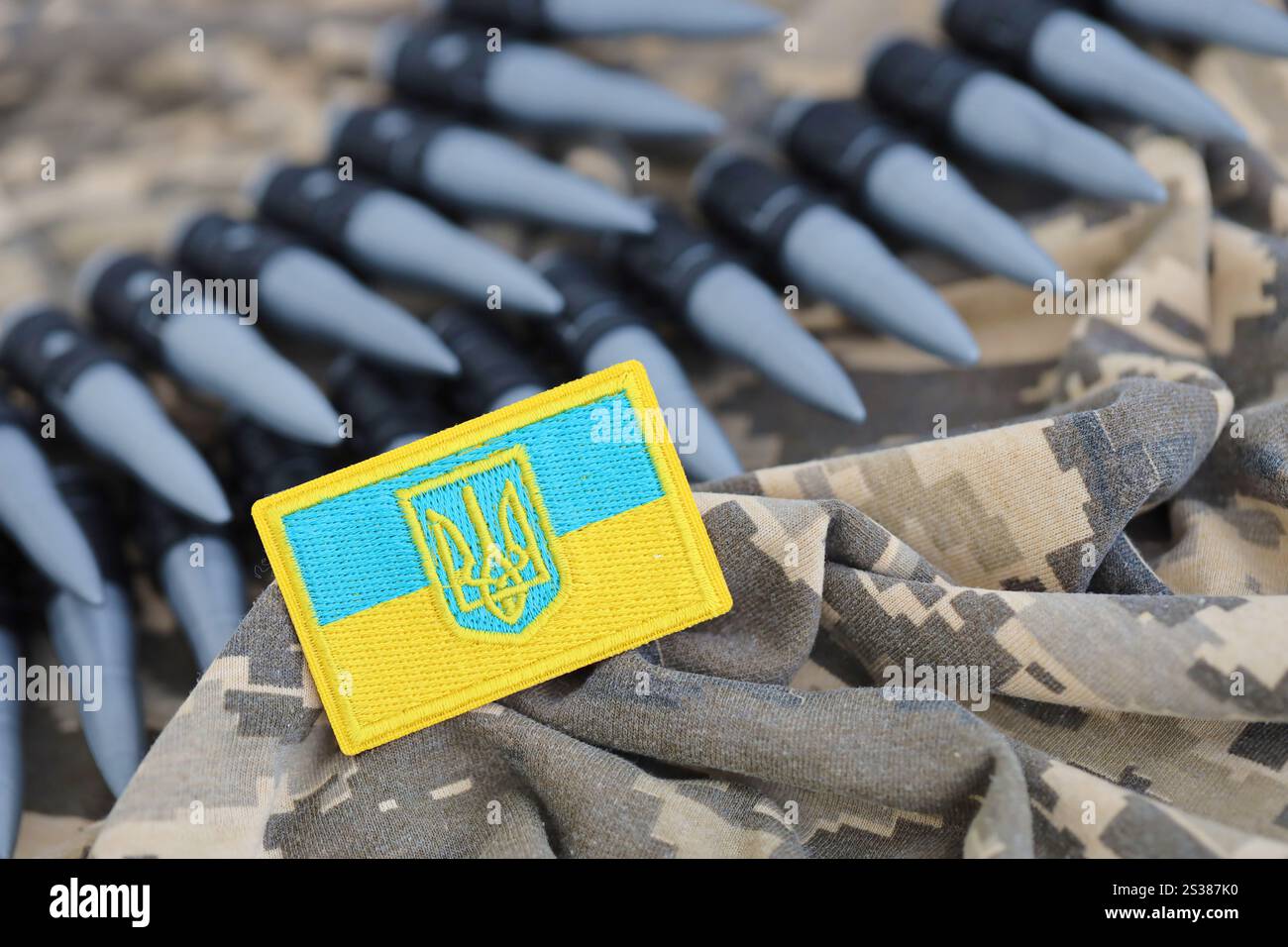 Ukrainisches Symbol und Maschinengewehrgürtel auf der Tarnuniform eines ukrainischen Soldaten. Der Begriff Krieg in der Ukraine, Patriotismus und Schutz Stockfoto