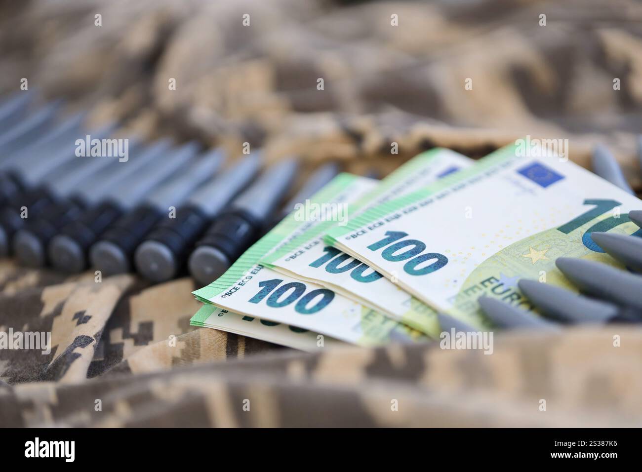 Bündel Euroscheine und ein Maschinengewehrgürtel auf der Tarnuniform eines ukrainischen Soldaten. Konzept der Kriegsfinanzierung, Bestechung oder Spende. Hilfe zu Stockfoto
