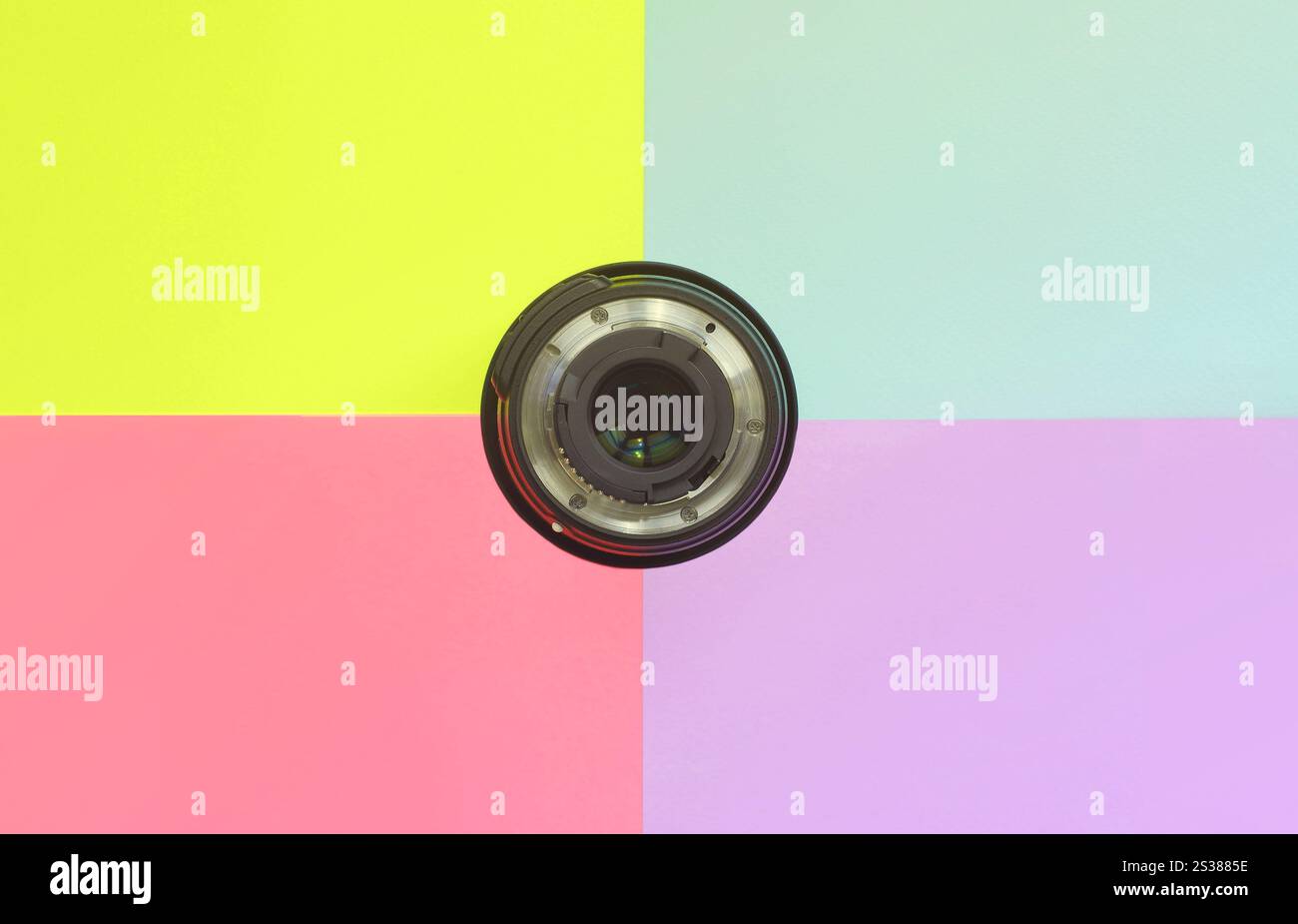 Minimalismus mit fotografischer Linse auf blauem, violettem, rosa und gelbem Hintergrund. Trendige Pastellfarben. Draufsicht mit flacher Lage. Minimalismus mit Fotografie Stockfoto