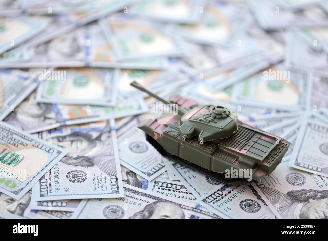 Spielzeugtank auf US-Dollar-Banknoten aus nächster Nähe. Das Konzept der Kriegskosten, der Militärausgaben und der Wirtschaftskrise. Spielzeugtank auf US Hundred Stockfoto