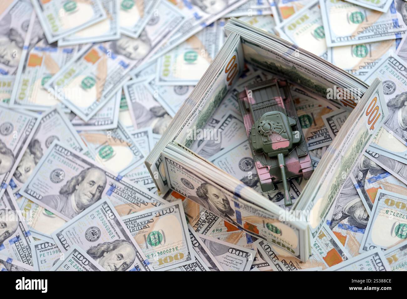 Spielzeugtank auf US-Dollar-Banknoten aus nächster Nähe. Das Konzept der Kriegskosten, der Militärausgaben und der Wirtschaftskrise. Spielzeugtank auf US Hundred Stockfoto